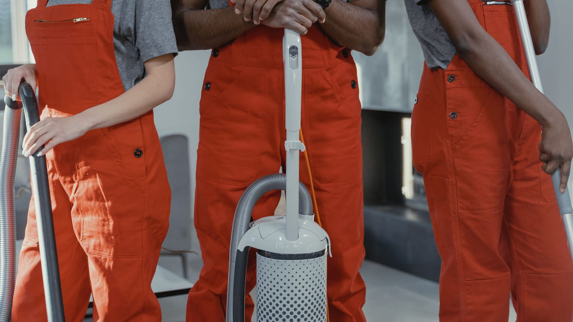 Cleaners with vacuums and mops, ready to start a job